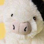 Jellycat Kuh Smudge Cow, Gesicht in Nahaufnahme vor einem gelben Hintergrund