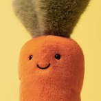 Jellycat Karotte Amuseables Carrot, Gesicht in Nahaufnahme vor einem gelben Hintergrund